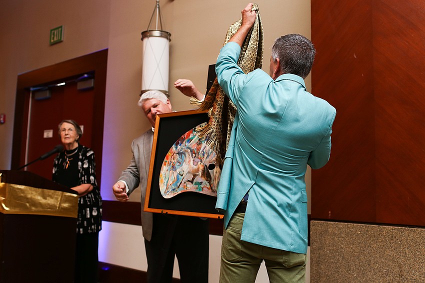 Eric Bowyer and Peter Imrik pull back the sheet to reveal the stolen painting being returned.