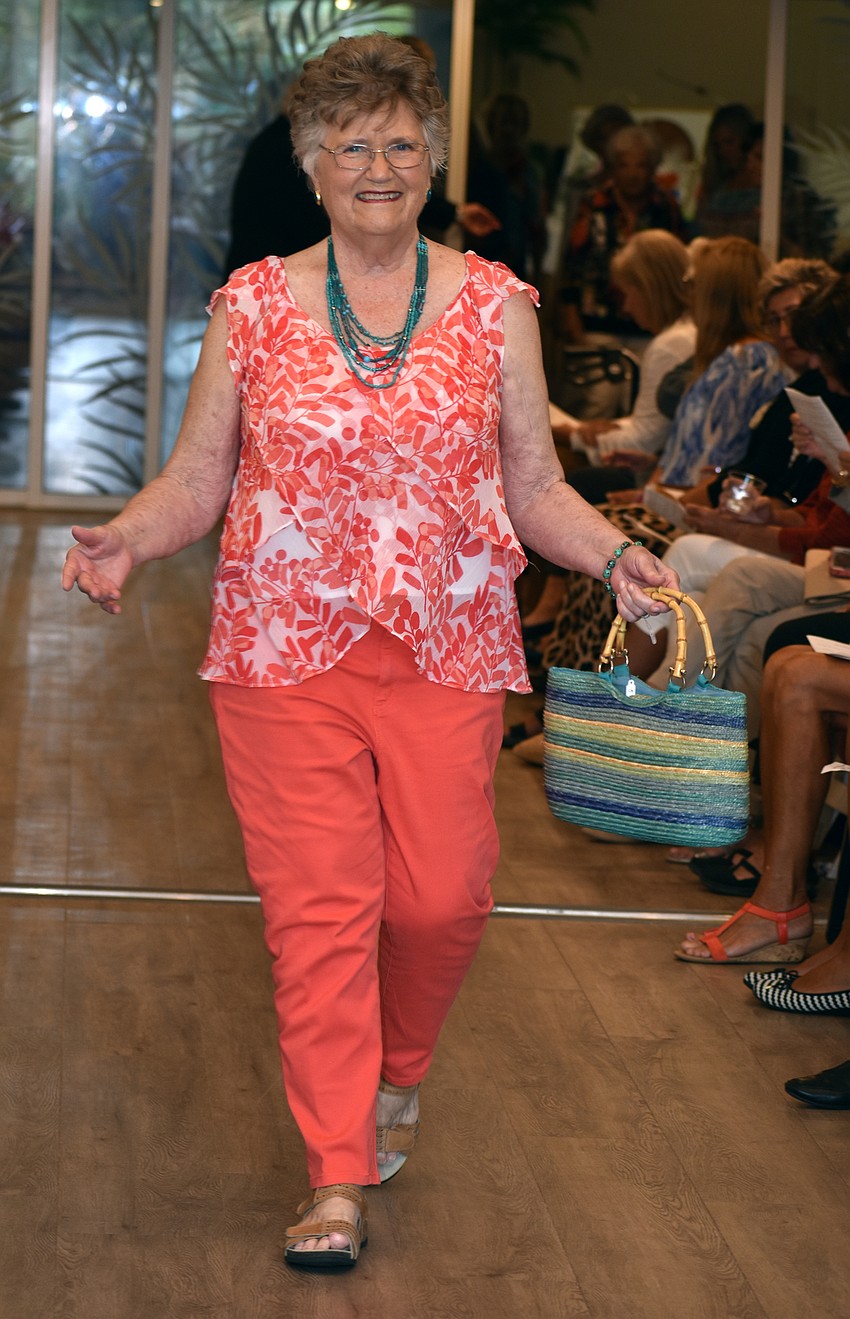 June McBride wears coral colors as she walks the runway.