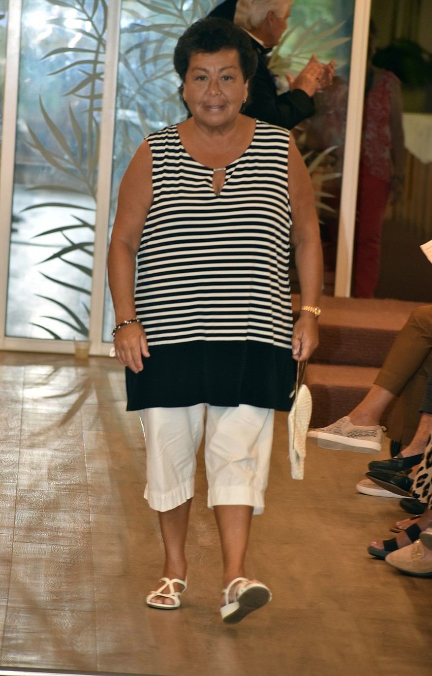 Mona Rios wears a black and white ensemble as she walks the runway.