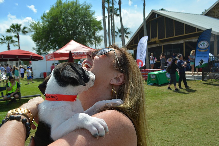 Kelly Abercrombie, who works in sales for Nassau Candy, gets a kiss from Dorothy, one of nine puppies taken in by Nate's who were named after Wizard of Oz characters.