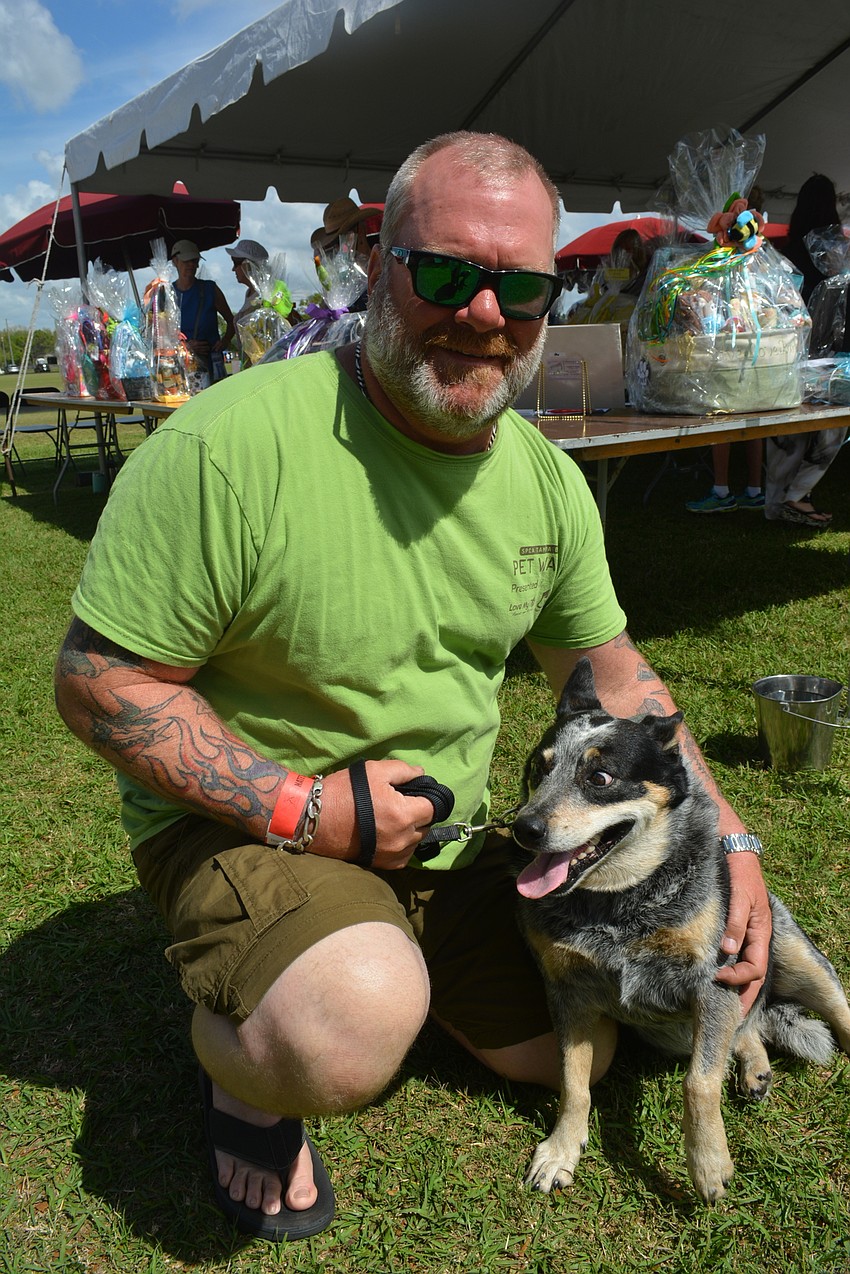 Myakka City's Steve Buron plays with Racine, a Blue Heeler his wife, Bonnie, rescued. Bonnie is a Nate's volunteer.