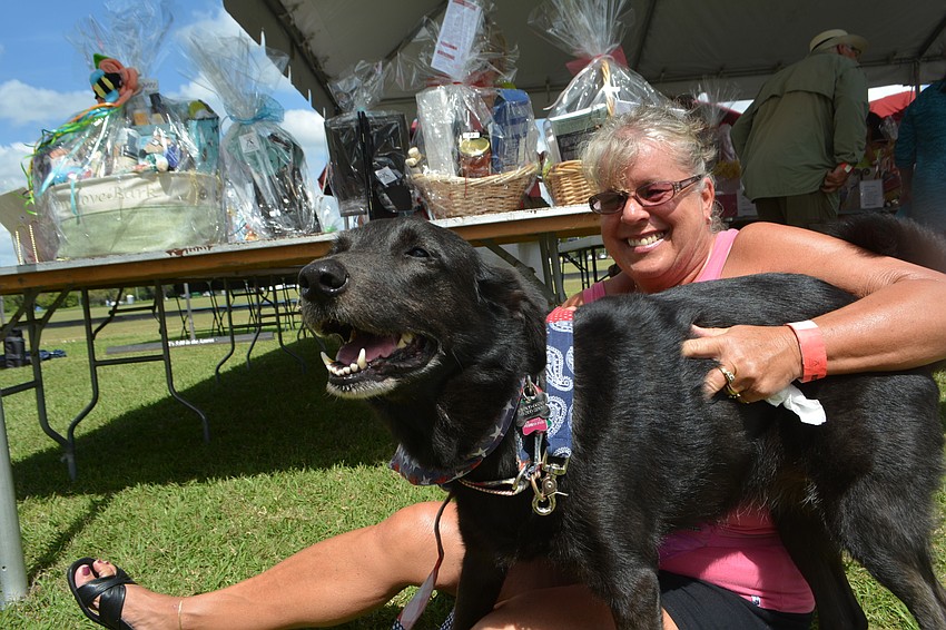 East County's Birgit Ferber tries to give her retriever mix, Inky, a hug before the polo match. Ferber is a Nate's volunteer.