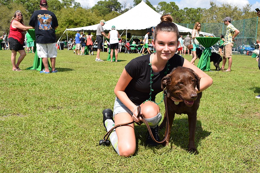 Mia Prodger, a Vista resident, crouches with her friend's dog, Killarney.
