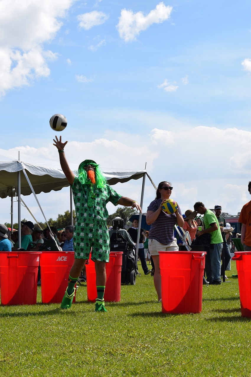 Chad Lowe, of Heritage Harbor, plays a jumbo-sized version of beer pong dressed head to toe in green.