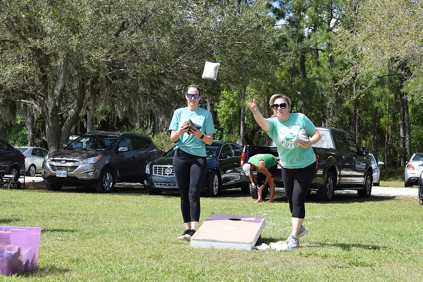 Tonia Brown, of Bradenton, and Tina Quintana, of Harbor Ridge, play cornhole at the festival.
