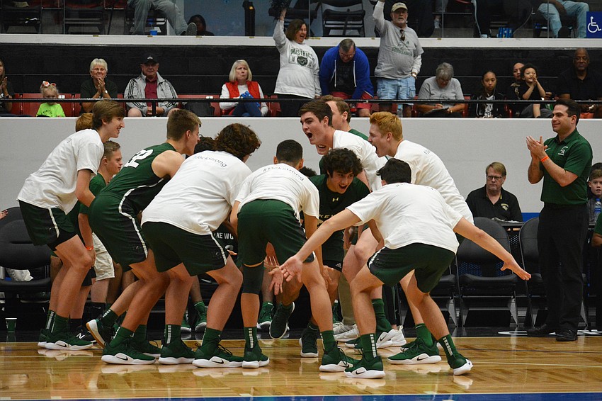 Junior guard Christian Perez (center) leads the Mustangs starters onto the floor as coach Jeremy Schiller (right) watches.
