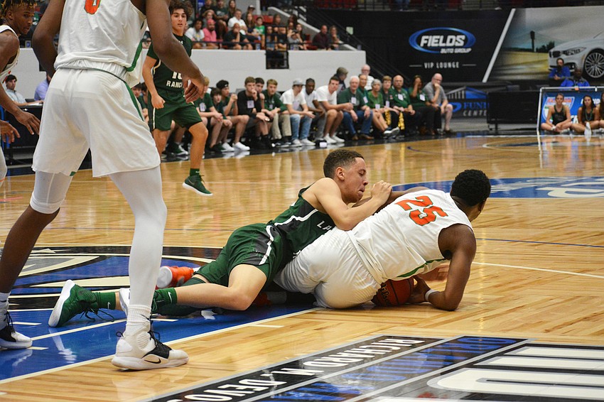 Junior guard Jaden Jones fights Blanche Ely senior forward Lance Rainer (25) for the ball.