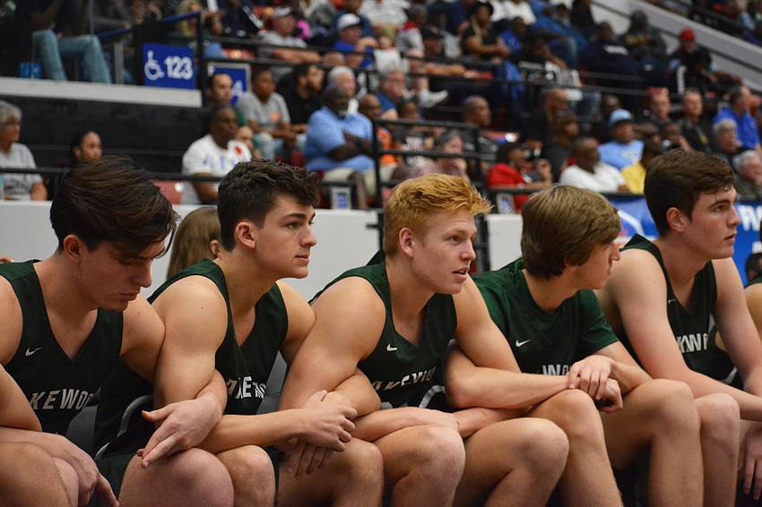The Mustangs bench — senior Alexander Baron, junior Maxwell Corsiglia, senior Dylan Wellard, junior Luke Lecroy and junior Carter Chapin — lock arms in solidarity late against Blanche Ely.