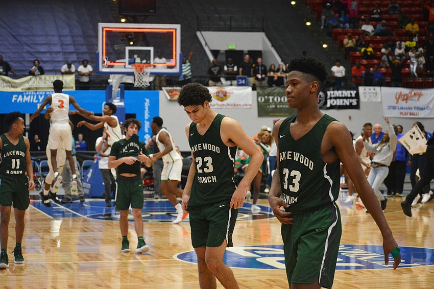 Senior Lantz Barton (11), junior Christian Perez, junior Christian Shaneyfelt and senior Josh Young leave the court as Blanche Ely celebrates its state title. The Tigers beat the Mustangs 57-52.