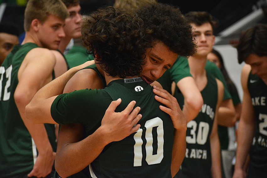 Junior guard Christian Perez (10) and junior guard Keon Buckley hug after the Mustangs loss to Blanche Ely.