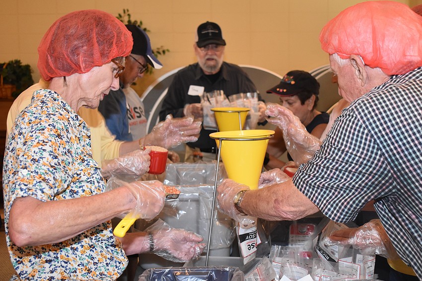 Volunteers had to funnel portions of rice and other portions of the meal packets.