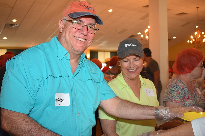 Fr. Wayne Farrell and Trish Farrell work to fill the bags.