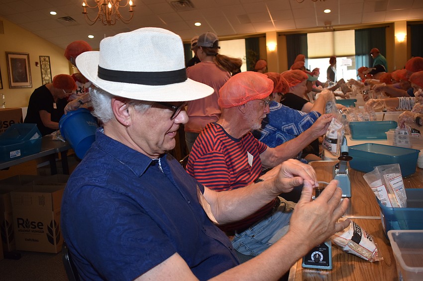 Michael Pate seals the bags containing the food.