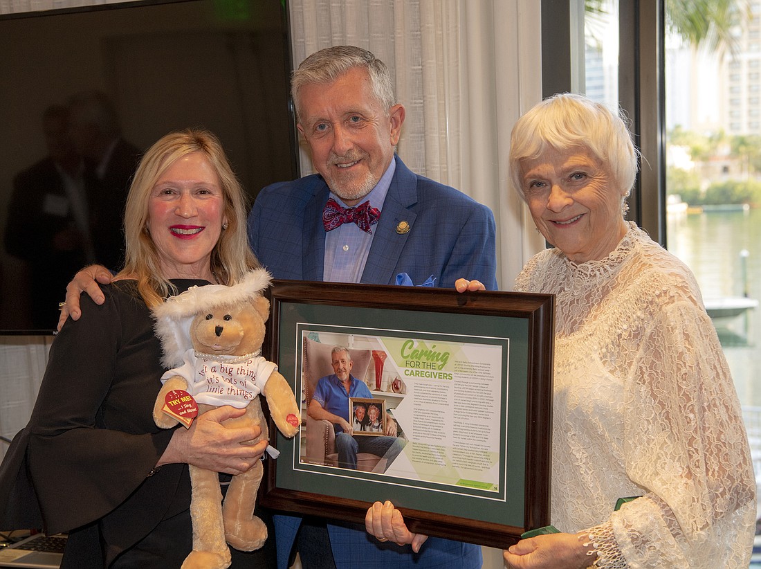 Joann Schoenbaum Miller, Phil King and Karen Holbrook hold a framed article referencing Philâ€™s estate gift and which shares a picture of Phil and Betty. Photo by Cliff Roles.