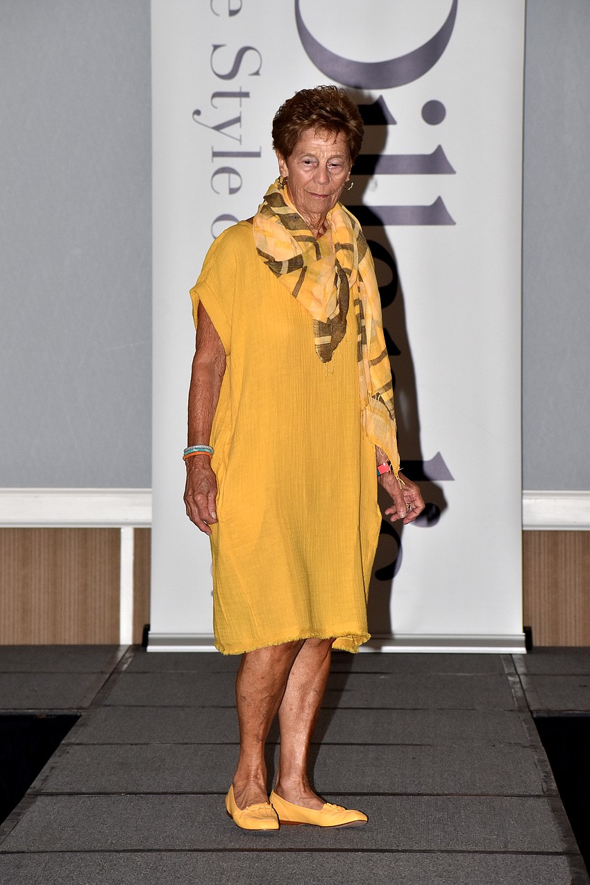 Dottie Pirelli models a marigold dress on the runway.