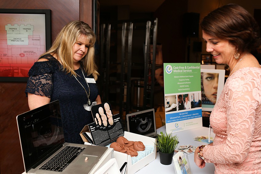Nichole King shows guests the differences between five and six-week-old babies.