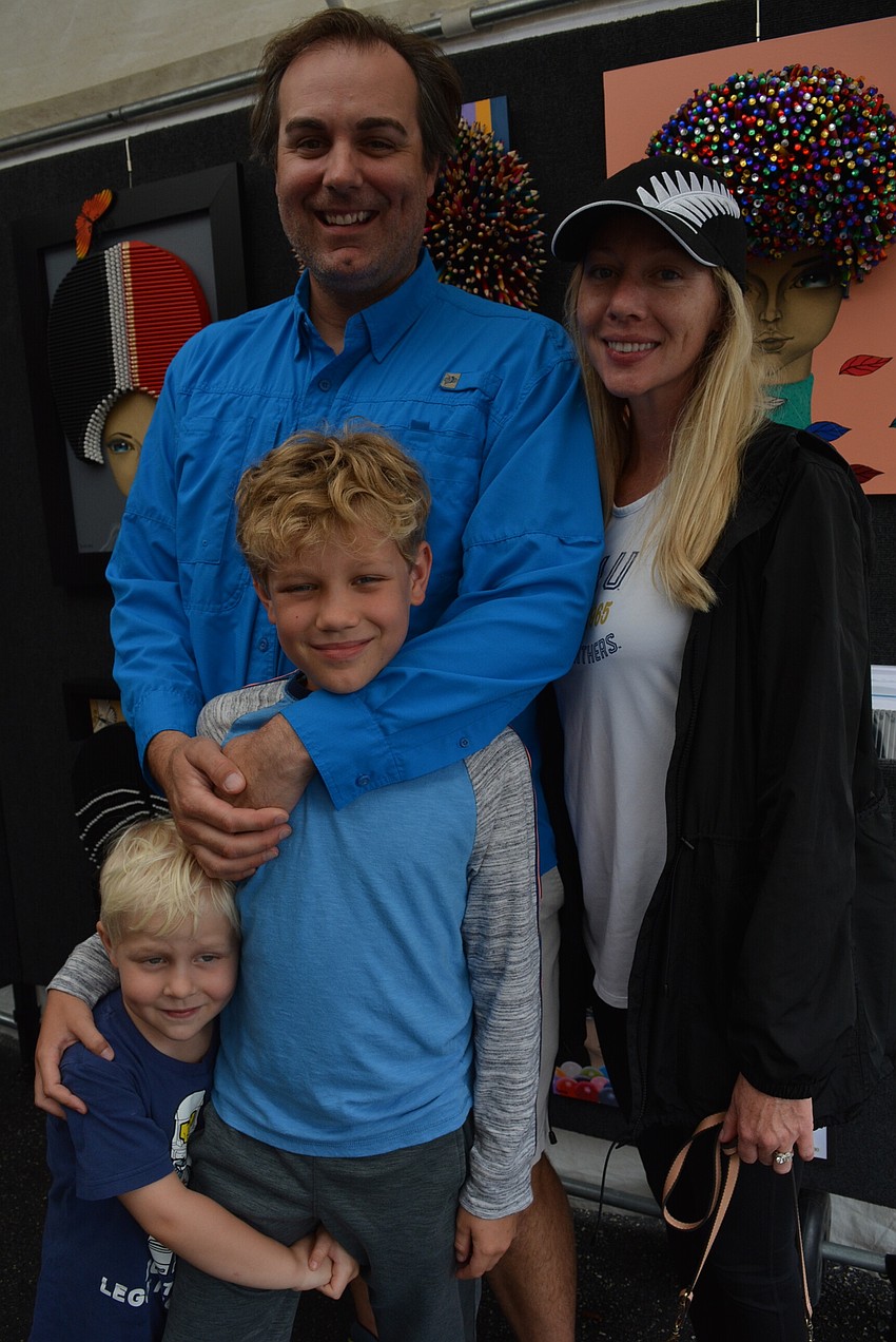 The Moseley family enjoy seeing all the art and check out Sip Tshun Ng Art, which pairs human faces with colored pencils and other writing utensils for hair.