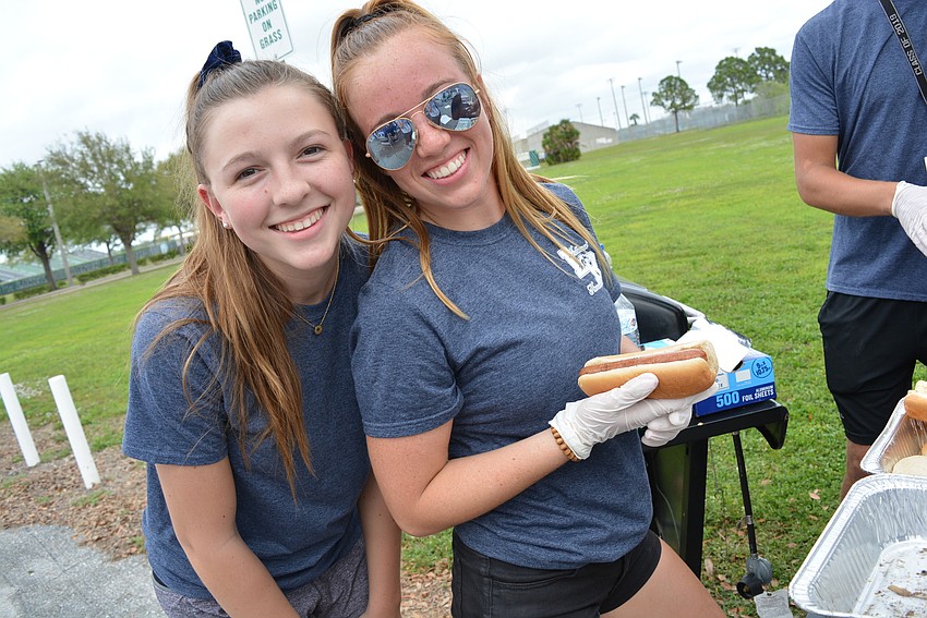 Lakewood Ranch National Honor Society members Emma Brooks and Katie Ridenour help serve hot dogs and hamburgers.