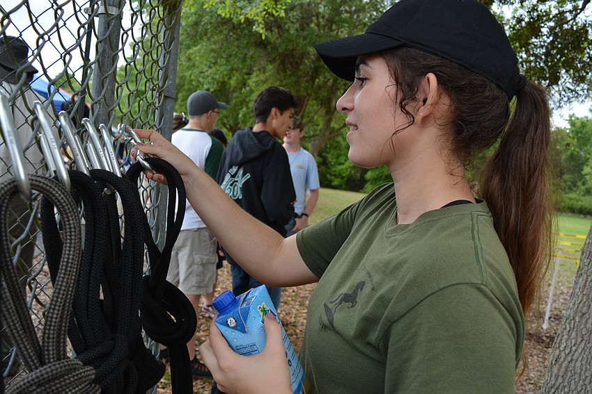 JROTC member Adina Mayo sets up  gear for participants in JROTC's obstacle course fundraiser.