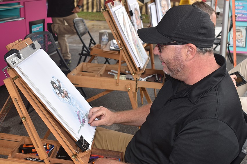 Ernie Turner draws a caricature.
