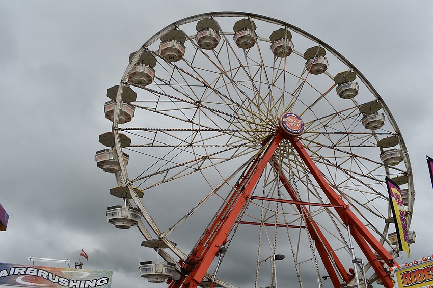 The ferris wheel still ran despite the stormy weather.