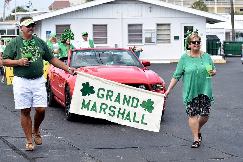 Gary Wise and Carol Lewis Weis parade with the grand marshal sign.