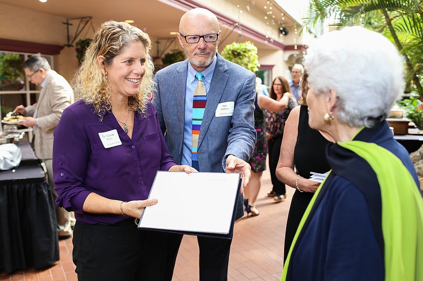 Allison Pinto and Tim Dutton give Nancy Schlossberg an award.