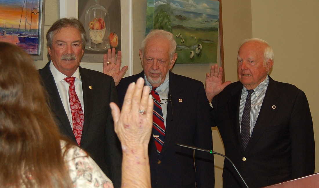 Town Clerk Trish Shinkle administers the oath of office to commissioners Mike Haycock, George Spoll and Jack Daly.