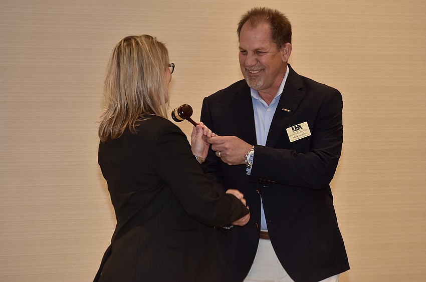 Mark Meador passes the gavel to Tonya Atchison, the new Chamber chairwoman.