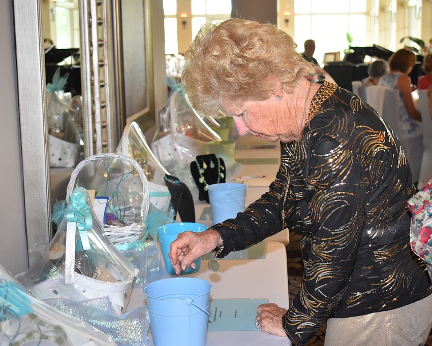 Mary Freeman bids on a raffle item for the Best Grandmother package, which included children's books and movie tickets.