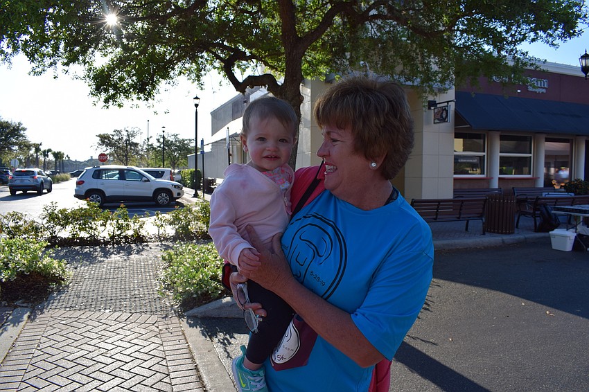 Joanne Ellis, of Lakewood Ranch, carries her granddaughter Madison Russell before the Beer Belly 5k.