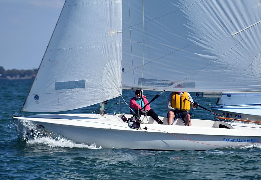 A crew member leans off the side of the boat in an effort to get it to turn.