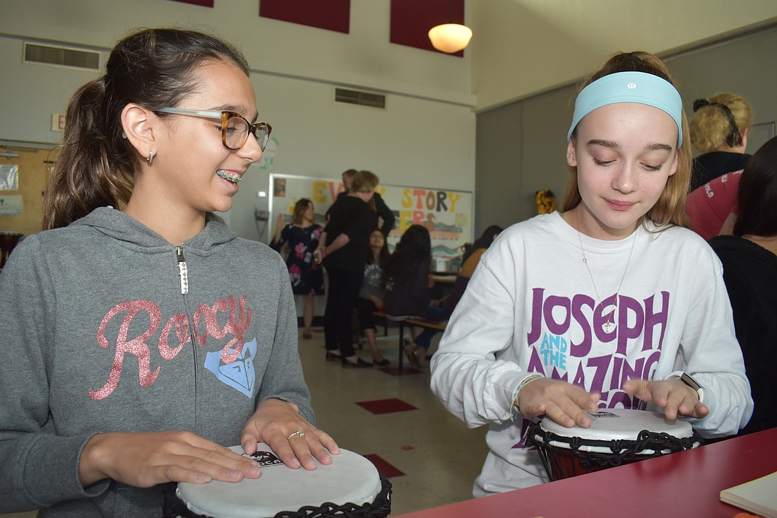 Anjolie Zerbini and Shayla White learn how to play the drums together.