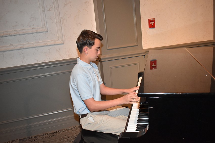 Johnny Robinson plays the piano before the reception begins.