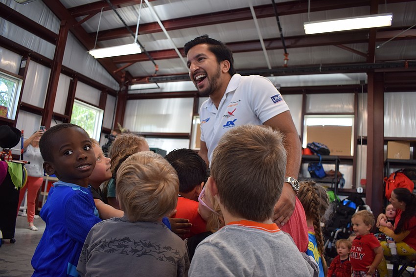 Powerboat P1 CEO Azam Rangoonwala, is hugged by preschoolers at The Haven.