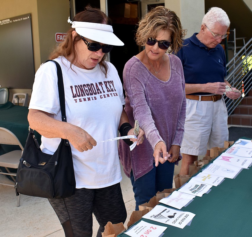 Jean Lacroix and Pat Cavall debate which bags to put their raffle tickets in.
