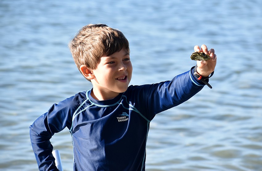 Parker Glassman holds up an oyster he found.