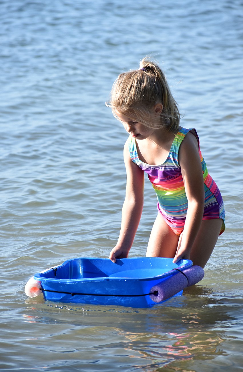 Madison Scott drags drags her tub into Sarasota Bay. Campers used the bins as a holding spot for any marine life they found.