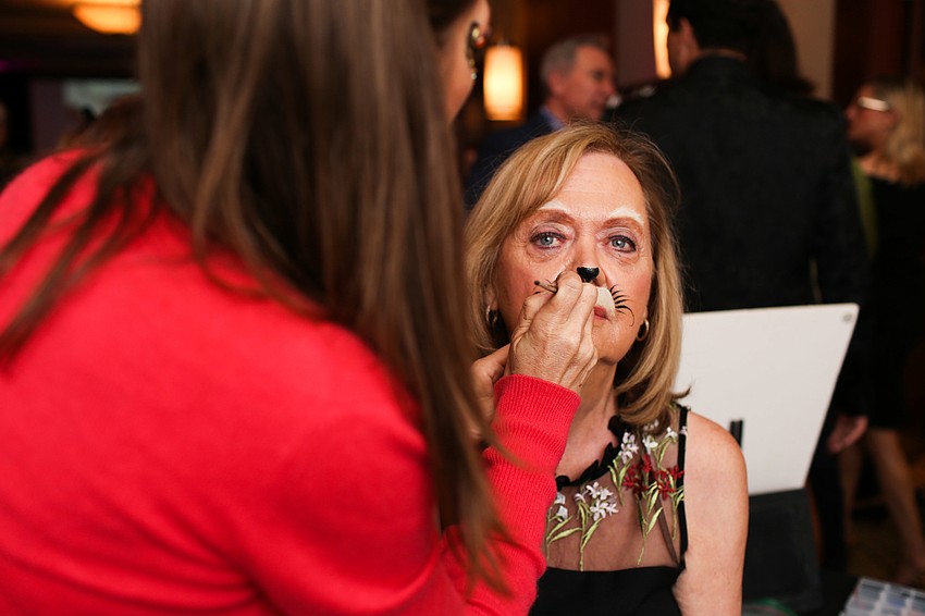 Lynn Epartington gets whiskers painted Suzy Kalin.