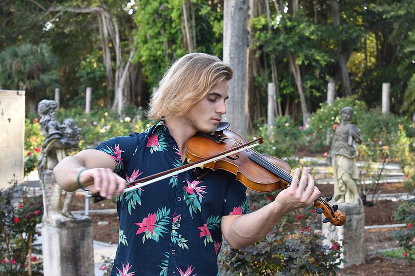 A violinist plays for guests at the Floral Arts Pavilion.
