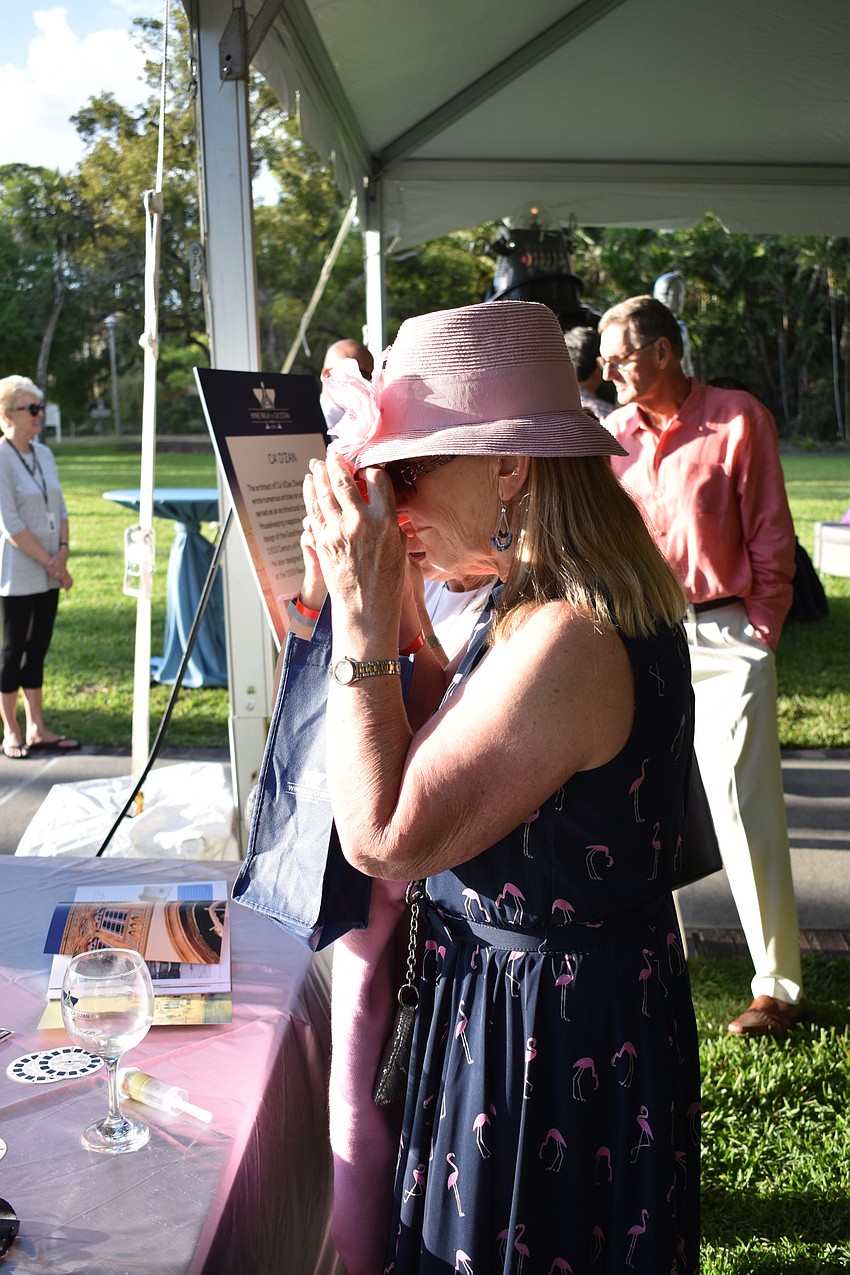 Karen Lee looks through a viewfinder to see old photos of what the interior of the Ca' d'Zan looked like when John and Mable Ringling lived there.