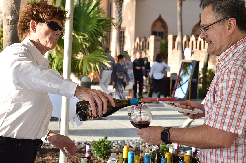 Pat Garbez of Total Wine pours a taste of Landway shiraz for a guest.