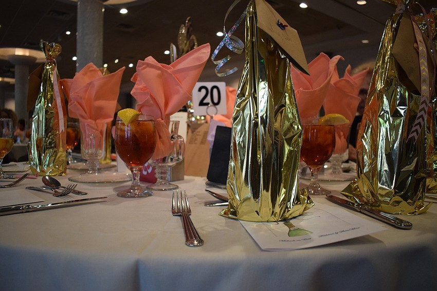 The place settings at the fashion show feature touches of gold and pink.