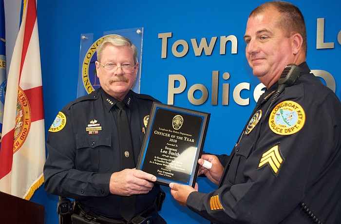 Longboat Key Police Chief Pete Cumming hands the Officer of the Year plaque to Sgt. Lee Smith.