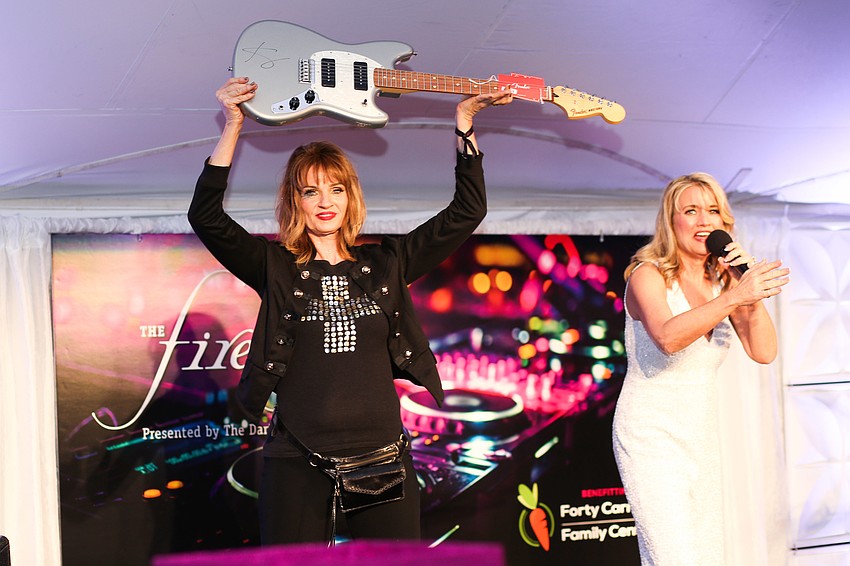 Tonya Gowan shows off the signed guitar in the live auction.