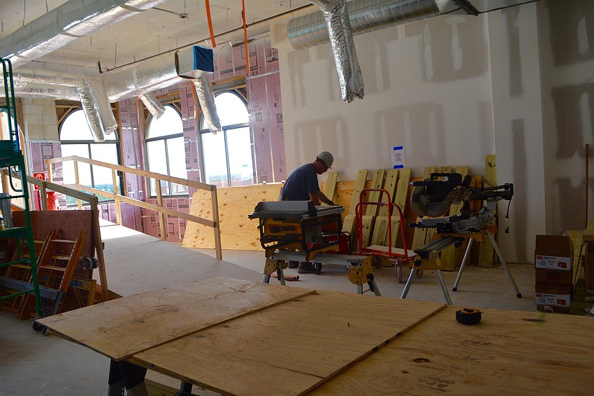 A worker cuts slabs of wood for the window designs on the tenth floor.