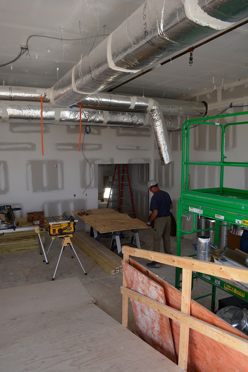 A worker cuts slabs of wood for the window designs on the tenth floor.