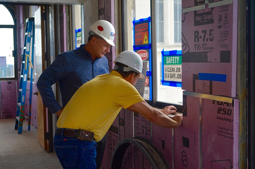 Project Manager Darryl Blair (left) and Superintendent Gene Cook (right) inspect a window on the tenth floor.