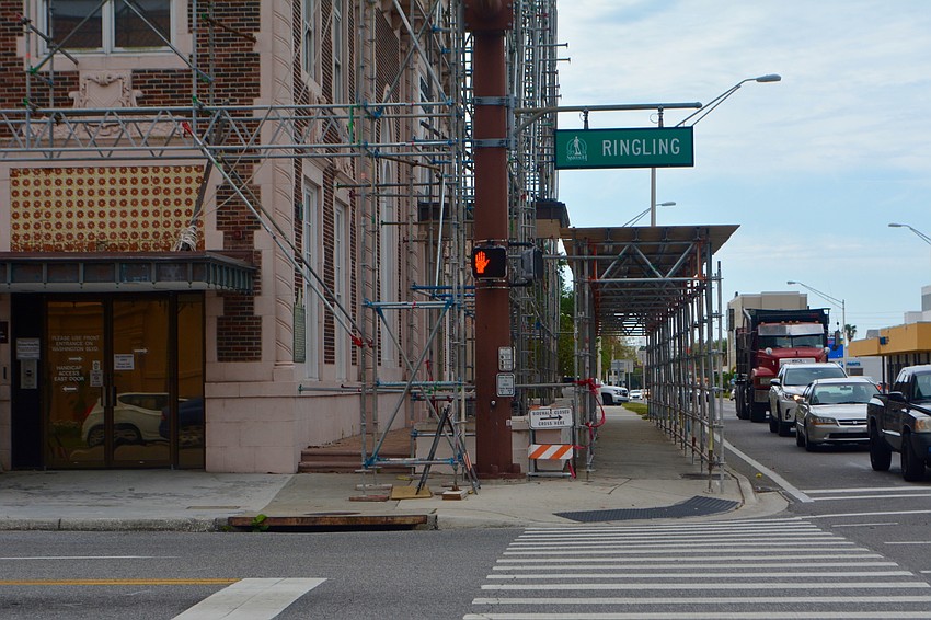 Scaffolding on the building also serves to protect pedestrians who walk by.