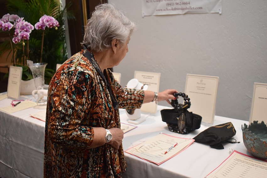 Ileane Smith peruses a silent auction of accessories and jewelry.